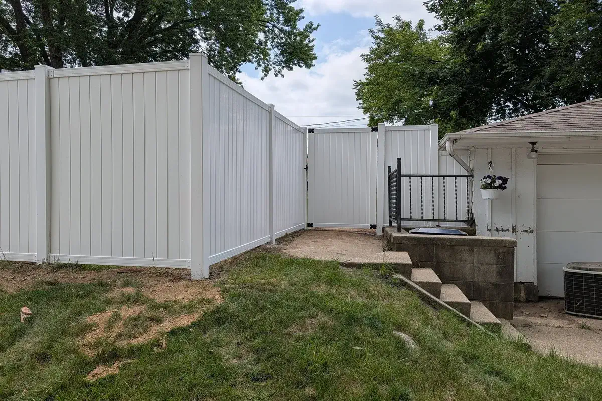 White vinyl fence and gate beside stone steps